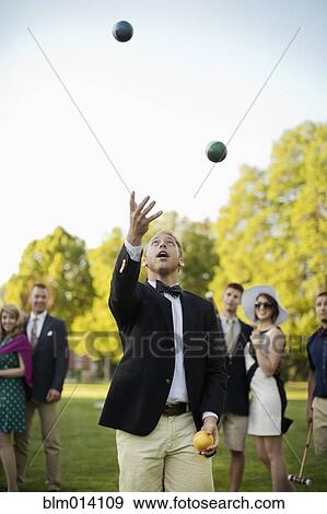 Stock Photo - Caucasian man juggling croquet balls. Fotosearch