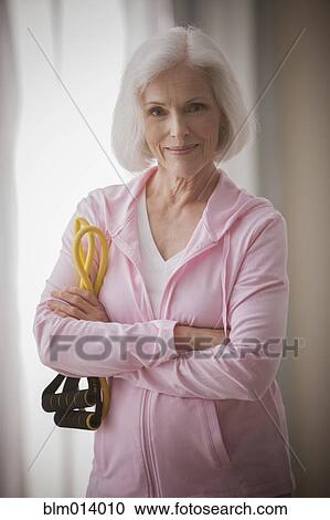 Stock Image - Caucasian woman holding resistance bands. Fotosearch