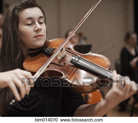Caucasian woman playing violin in orchestra View Large Photo Image Stock Image - Caucasian woman playing violin in orchestra. Fotosearch