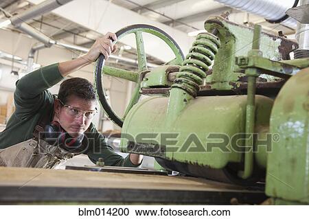 Caucasian worker cutting lumber in factory View Large Photo Image Stock Image - Caucasian worker cutting lumber in factory. Fotosearch