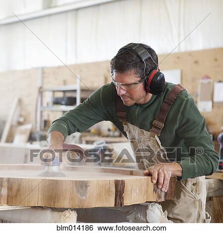 Caucasian worker sanding wood in factory View Large Photo Image Stock Photograph - Caucasian worker sanding wood in factory. Fotosearch