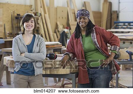 Stock Photo - Co-workers standing together in factory. Fotosearch