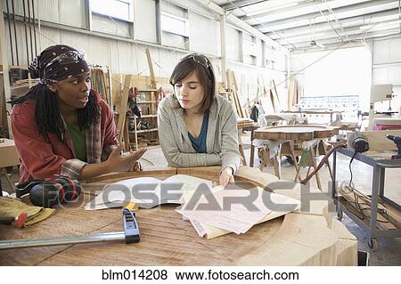 Stock Photo - Co-workers working together in factory. Fotosearch