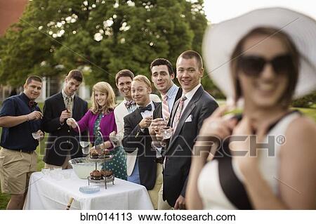 Stock Image - Elegant friends having a party on the lawn. Fotosearch