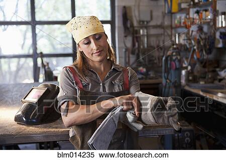 Hispanic factory worker putting on gloves View Large Photo Image Stock Photography - Hispanic factory worker putting on gloves. Fotosearch