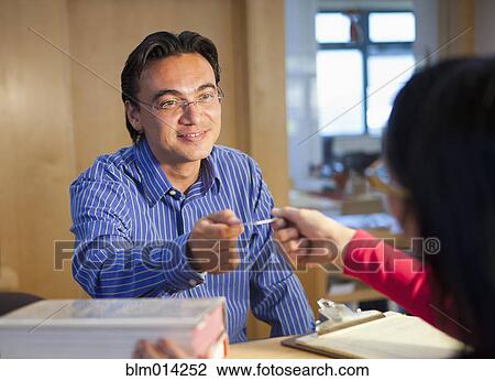 Hispanic man checking out books with library card View Large Photo Image Stock Image - Hispanic man checking out books with library card. Fotosearch