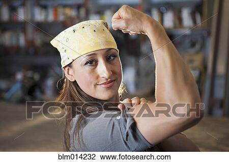 Stock Image - Hispanic worker flexing biceps. Fotosearch