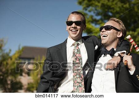 Stock Photo - Laughing men hugging and holding croquet mallet. Fotosearch