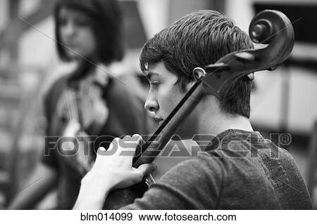 Man playing cello in orchestra View Large Photo Image Stock Photo - Man playing cello in orchestra. Fotosearch