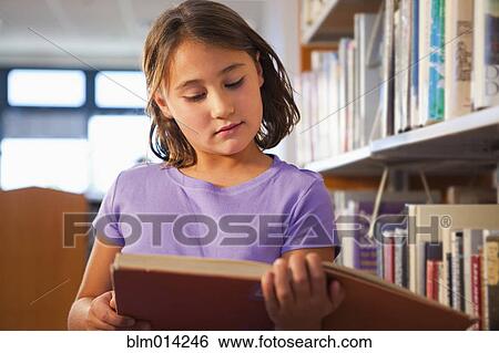 Mixed race girl reading book in library View Large Photo Image Stock Photograph - Mixed race girl reading book in library. Fotosearch