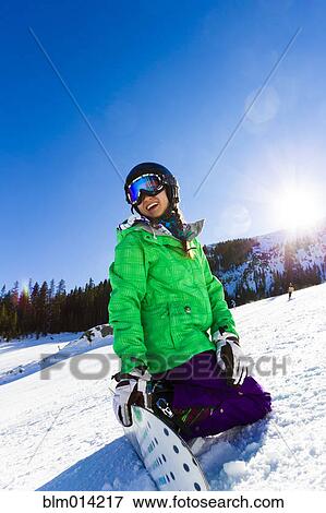 Stock Photo - Mixed race teenager snowboarding. Fotosearch