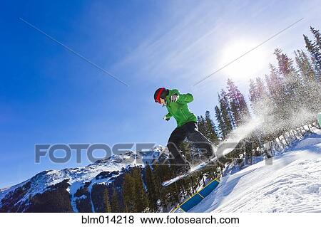 Stock Photo - Mixed race teenager snowboarding. Fotosearch