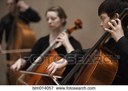 Stock Photo - Musicians playing cello in orchestra. Fotosearch