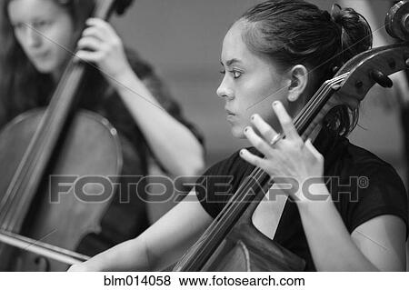 Musicians playing cello in orchestra View Large Photo Image Stock Photo - Musicians playing cello in orchestra. Fotosearch