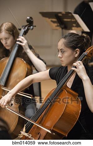 Stock Photo - Musicians playing cello in orchestra. Fotosearch