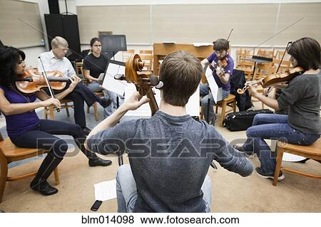 Stock Photo - Musicians playing together in classroom. Fotosearch
