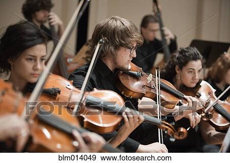 Orchestra playing violins View Large Photo Image Stock Photo - Orchestra playing violins. Fotosearch