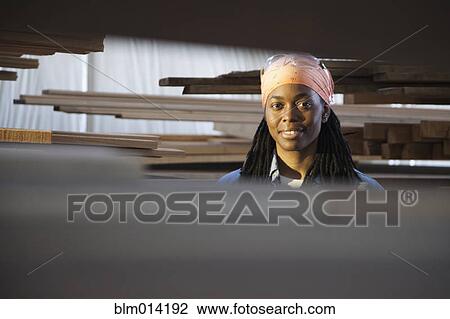Stock Image - Smiling Black worker in factory. Fotosearch