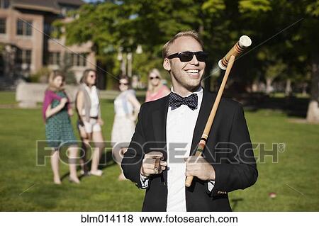 Stock Photo - Smiling Caucasian man holding croquet mallet. Fotosearch