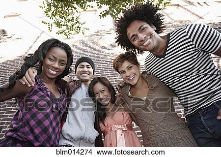 Picture - Smiling friends standing together hugging. Fotosearch