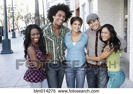 Stock Photography - Smiling friends standing together hugging. Fotosearch