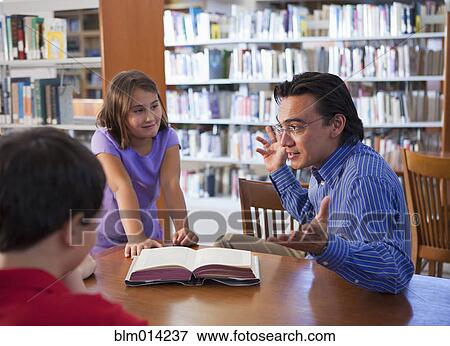 Teacher talking to students in library View Large Photo Image Stock Photo - Teacher talking to students in library. Fotosearch