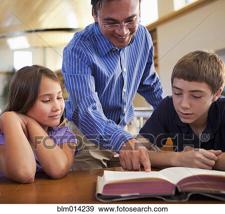 Teacher talking to students in library View Large Photo Image Stock Photo - Teacher talking to students in library. Fotosearch