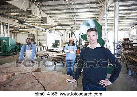 Workers standing with wood in factory View Large Photo Image Stock Photograph - Workers standing with wood in factory. Fotosearch