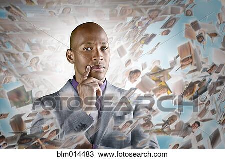 Stock Image - African American businessman surrounded by images of business people. Fotosearch