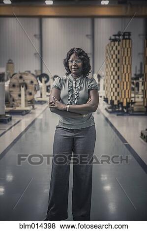 Stock Photo - African American worker standing in factory. Fotosearch