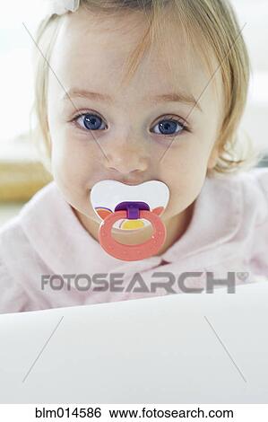 Baby girl sucking pacifier View Large Photo Image Stock Photograph - Baby girl sucking pacifier. Fotosearch
