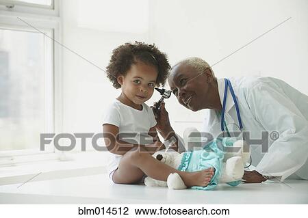 Stock Image - Black doctor examining girl. Fotosearch