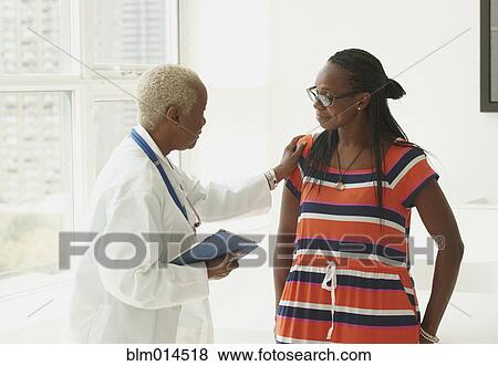 Stock Photo - Black doctor talking with patient. Fotosearch