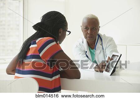 Black doctor using digital tablet with patient View Large Photo Image Stock Photograph - Black doctor using digital tablet with patient. Fotosearch