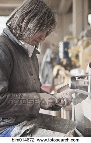 Stock Image - Carpenter working in woodshop. Fotosearch