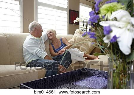 Stock Image - Caucasian couple sitting on sofa. Fotosearch