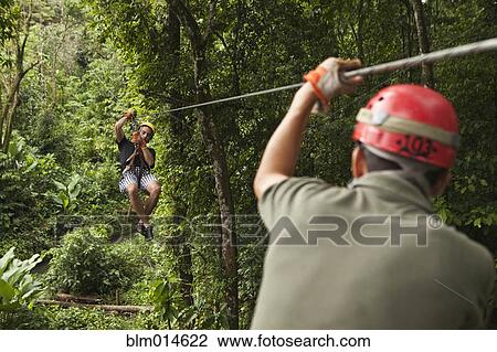 Caucasian man on zip line in forest View Large Photo Image Stock Image - Caucasian man on zip line in forest. Fotosearch