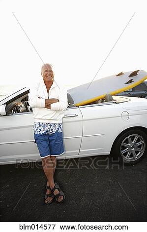 Caucasian man standing with car and paddleboard View Large Photo Image Stock Photo - Caucasian man standing with car and paddleboard. Fotosearch