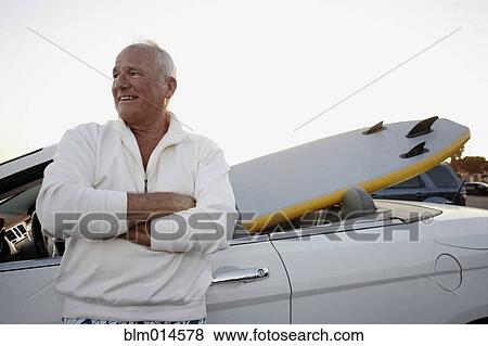 Caucasian man standing with car and paddleboard View Large Photo Image Stock Photo - Caucasian man standing with car and paddleboard. Fotosearch