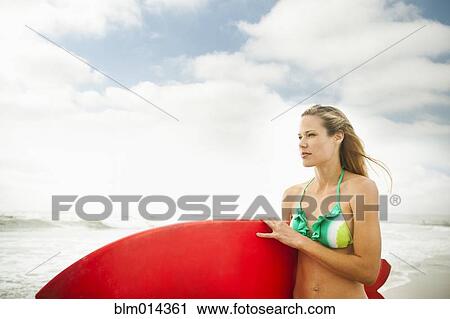 Caucasian woman carrying surfboard View Large Photo Image Stock Image - Caucasian woman carrying surfboard. Fotosearch