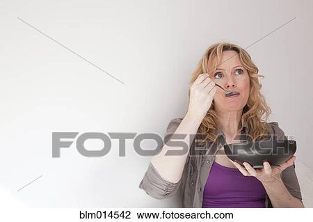 Stock Image - Caucasian woman eating soup. Fotosearch