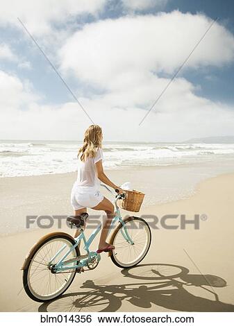 Caucasian woman riding bicycle on beach View Large Photo Image Stock Photograph - Caucasian woman riding bicycle on beach. Fotosearch