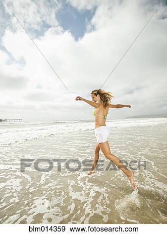 Caucasian woman running in ocean View Large Photo Image Stock Photo - Caucasian woman running in ocean . Fotosearch