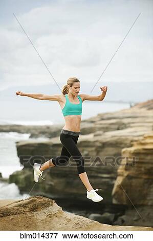 Stock Photo - Caucasian woman running on beach. Fotosearch