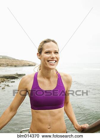 Stock Image - Caucasian woman standing near ocean. Fotosearch
