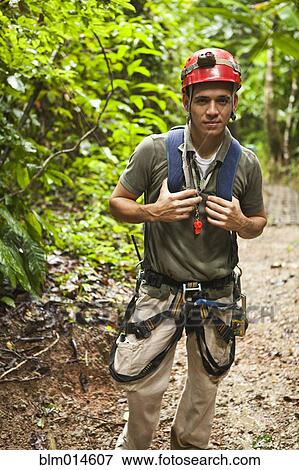 Stock Photo - Hispanic man in zip line gear. Fotosearch