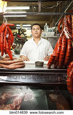 Stock Photo - Hispanic man working in butcher shop. Fotosearch