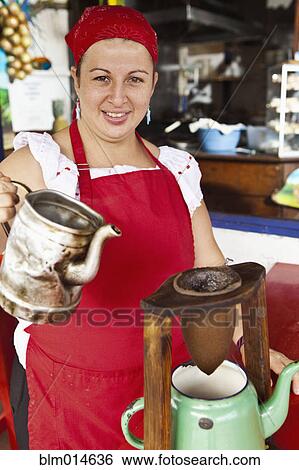Stock Photograph - Hispanic woman making coffee in restaurant. Fotosearch
