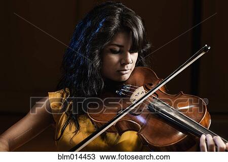 Stock Image - Hispanic woman playing violin. Fotosearch