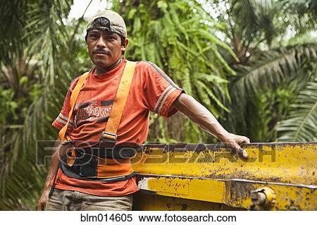 Hispanic worker leaning equipment View Large Photo Image Stock Photography - Hispanic worker leaning equipment. Fotosearch
